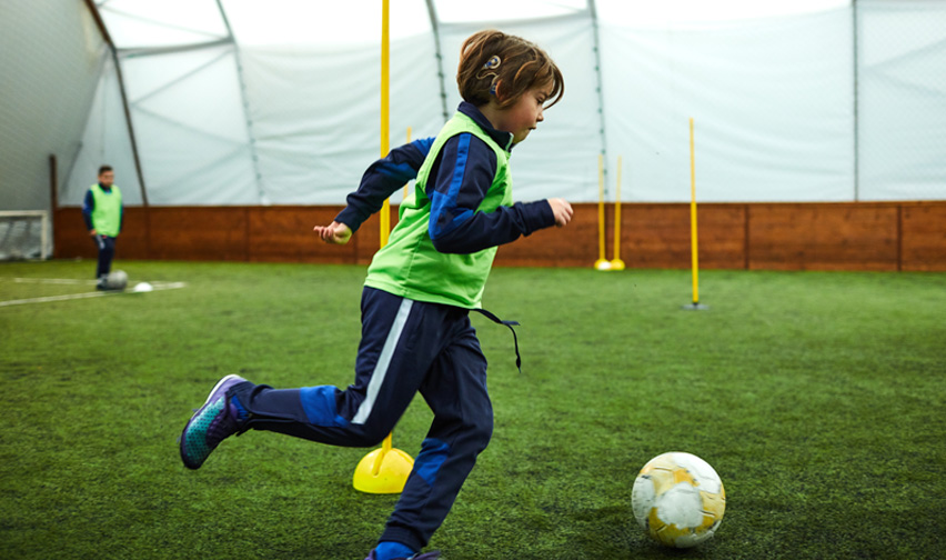 child with hearing device playing sport